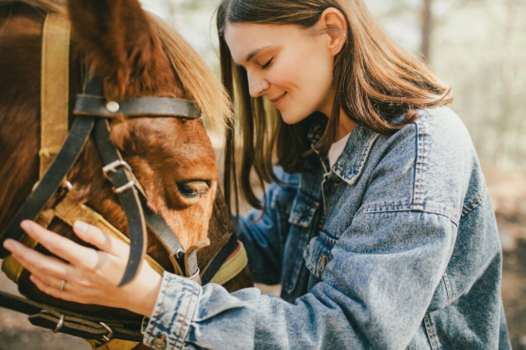 A young woman hugging a horse.